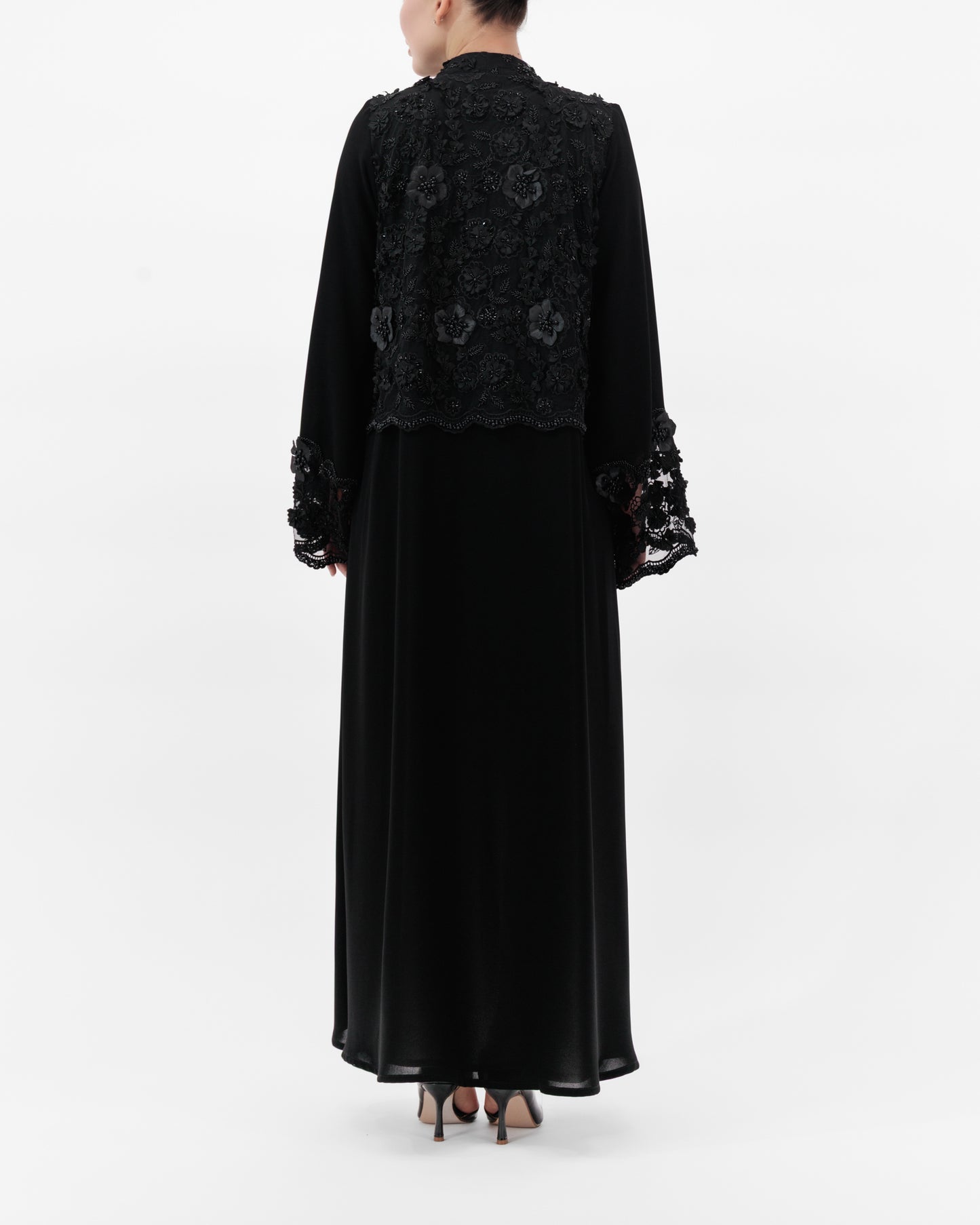 Black embroidered dress with long sleeves on a white background