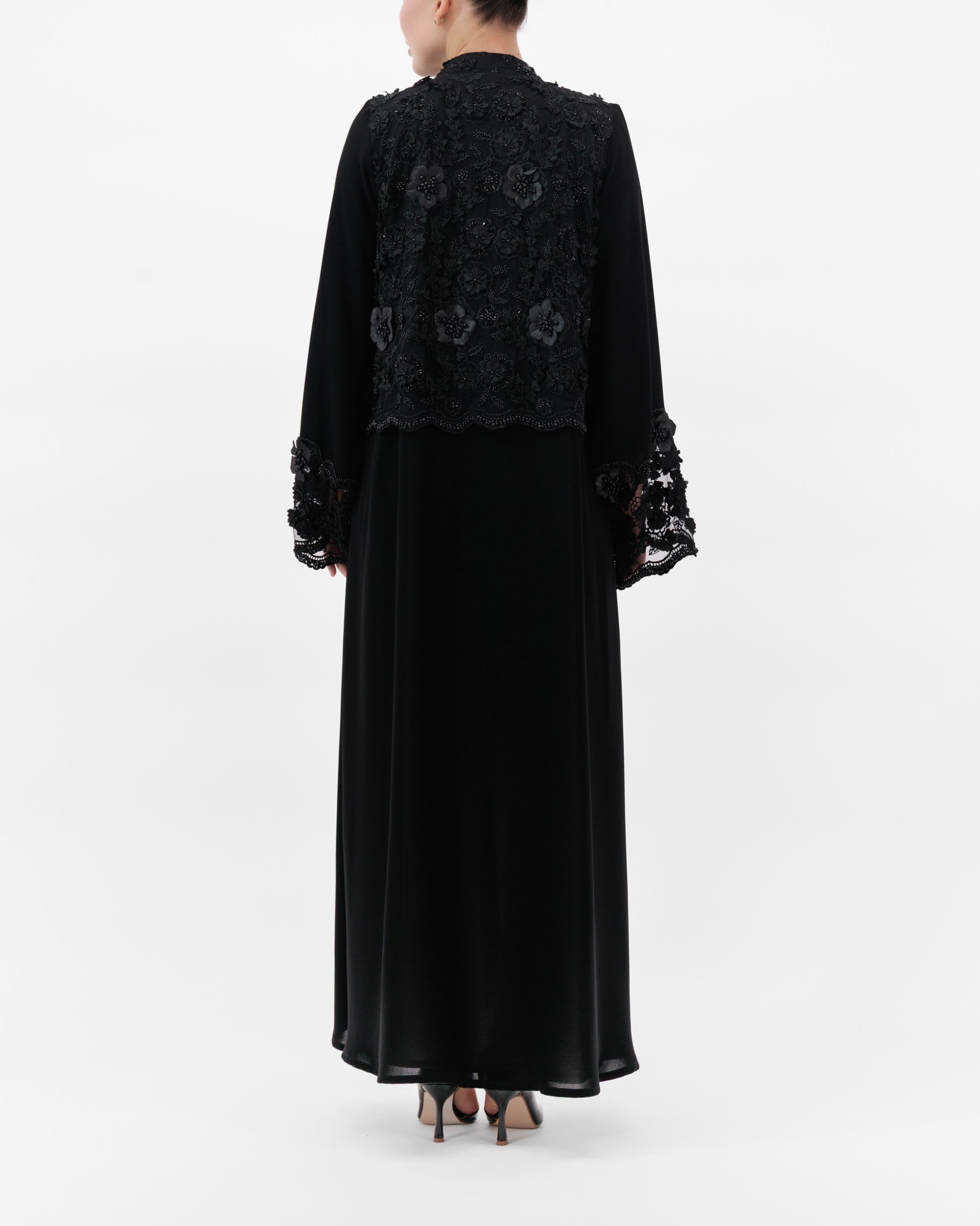 Black embroidered dress with long sleeves on a white background
