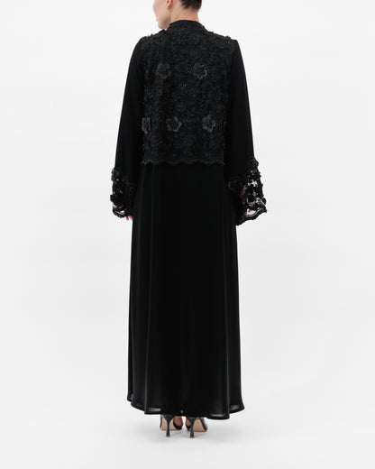 Black embroidered dress with long sleeves on a white background
