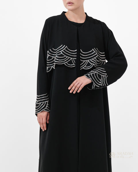 Regalia abaya — Nidha — black — wave-pattern embellishment — side profile

