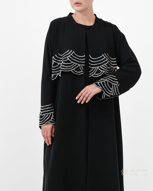 Regalia abaya — Nidha — black — wave-pattern embellishment — side profile

