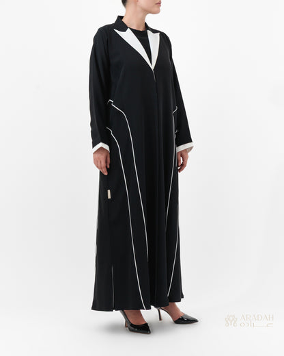 Black abaya with white accents worn by a model on a white background