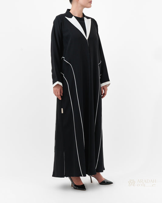 Black abaya with white accents worn by a model on a white background