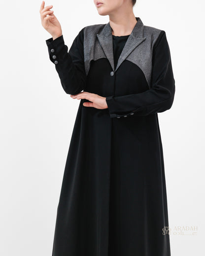Black coat with gray lapels worn by a person on a white background