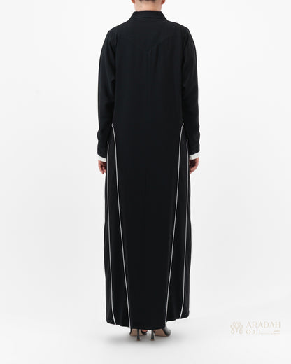 Black long-sleeve dress with white trim on a white background
