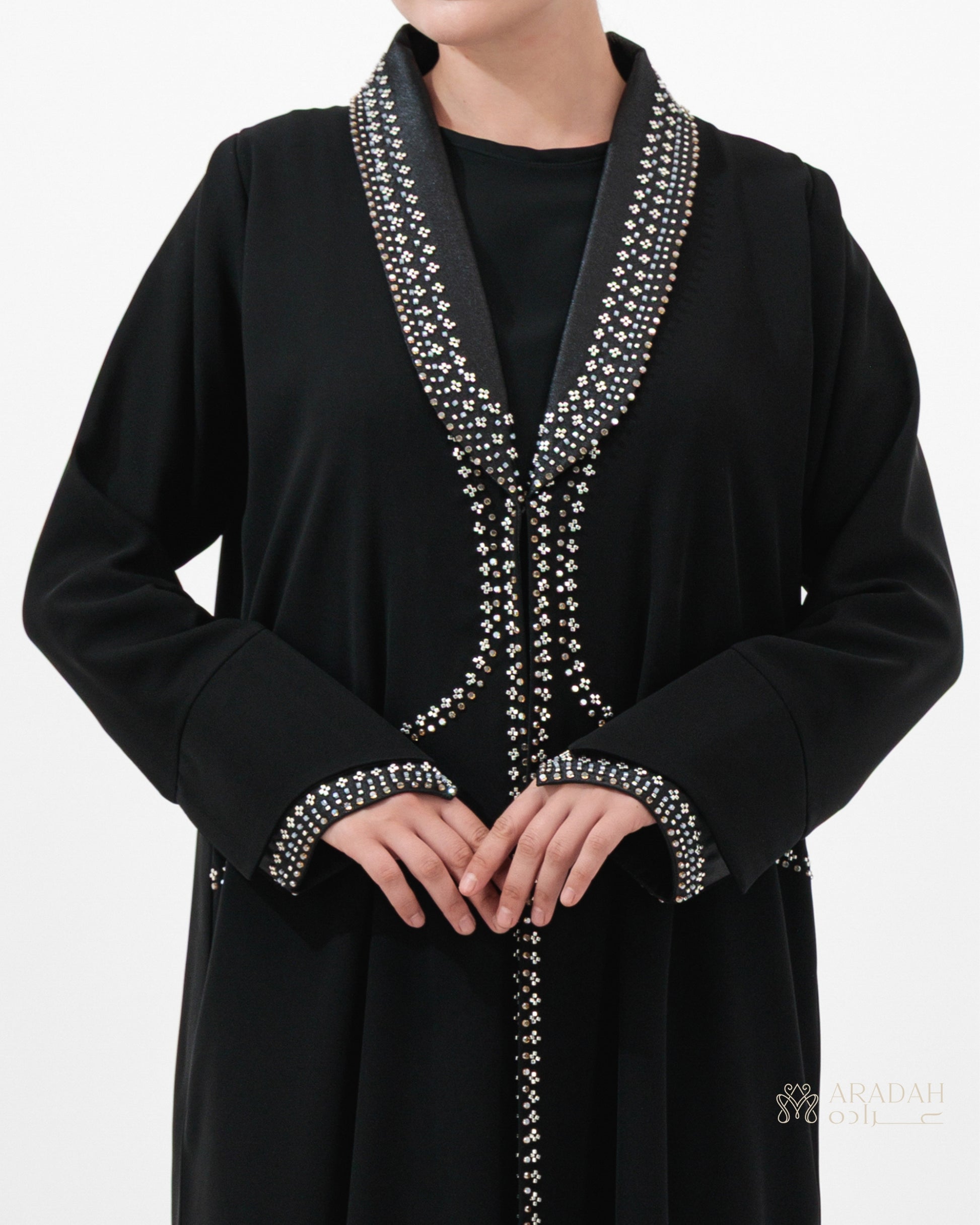 Black abaya with silver embroidery on a white background