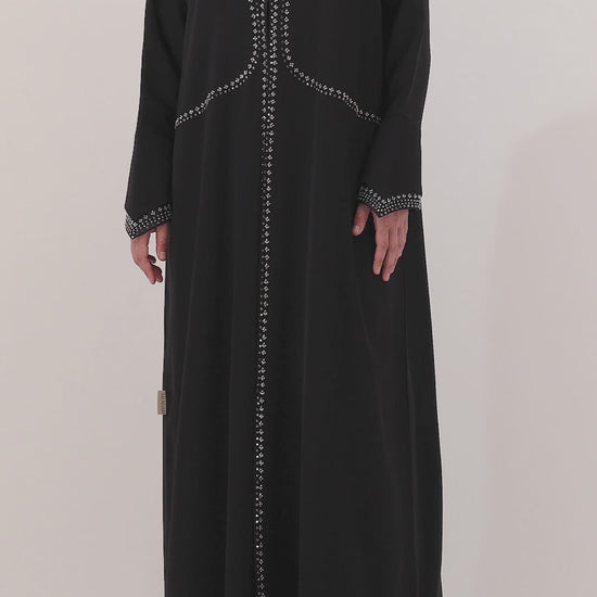 Black abaya with silver embroidery on a white background