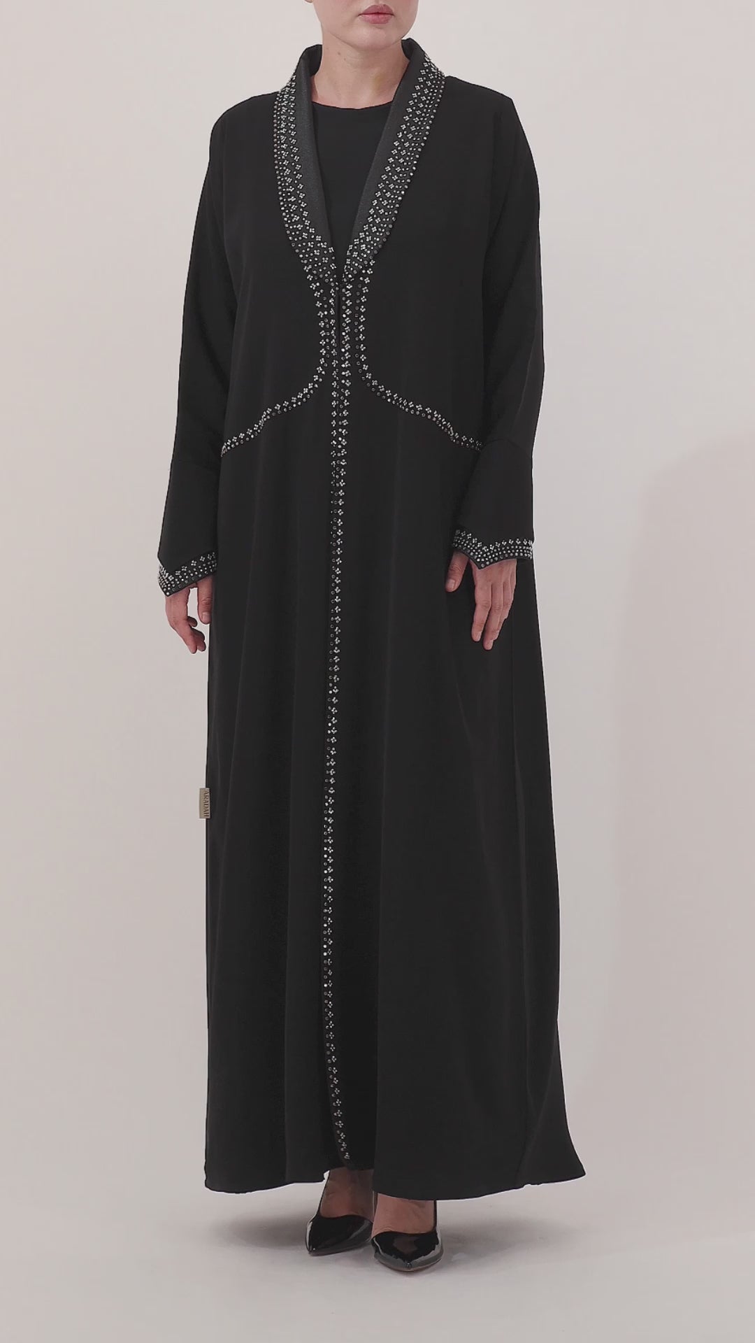 Black abaya with silver embroidery on a white background